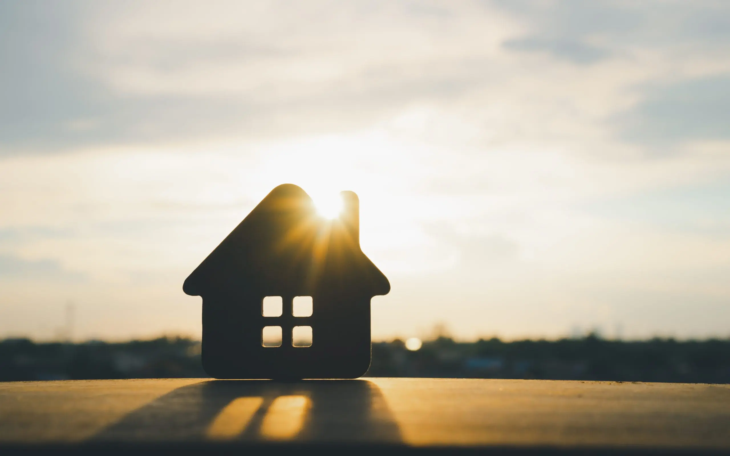 Modèle de maison en bois sur fond en bois, un symbole de vente immobilière